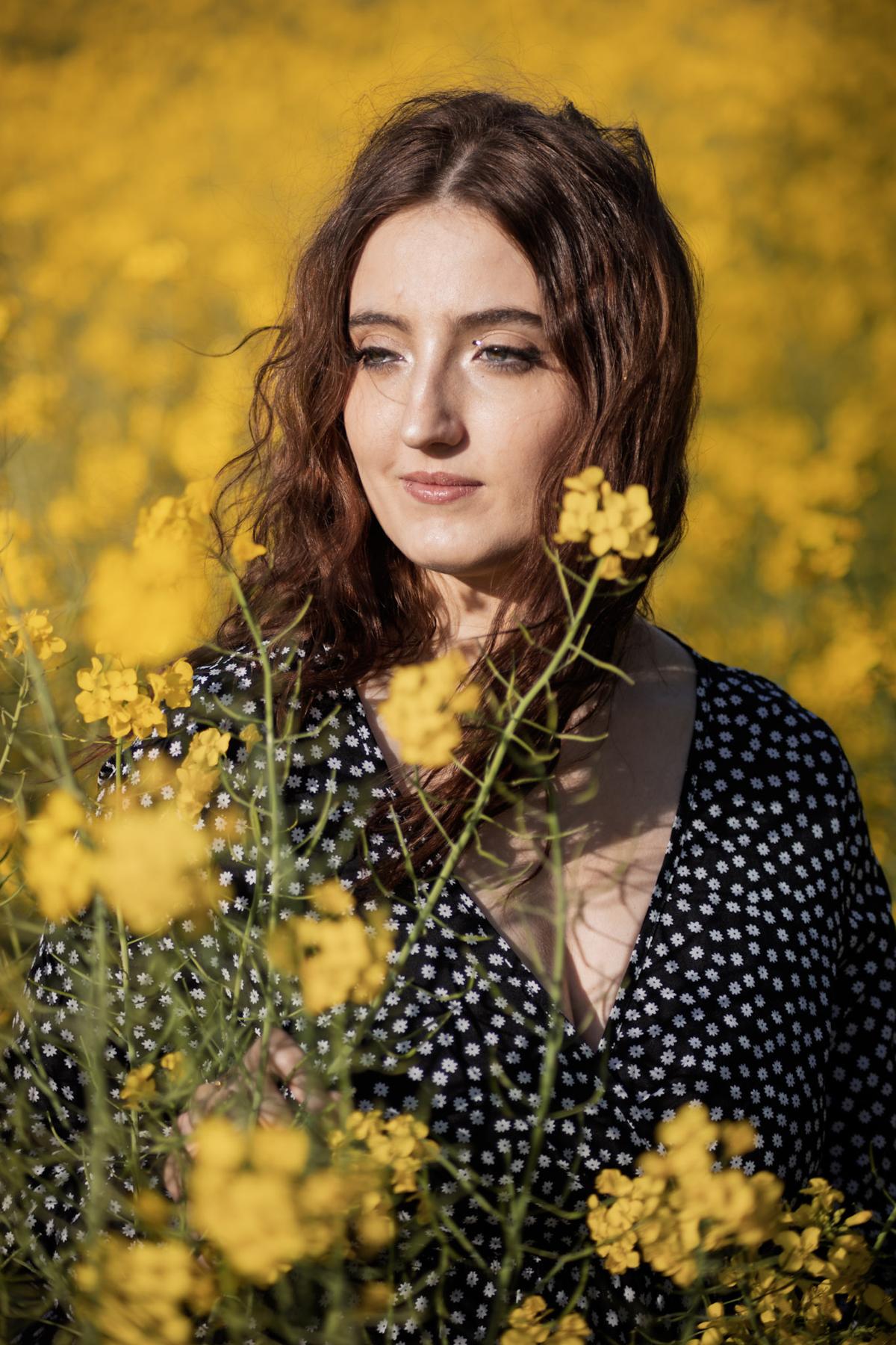Portrait dans les champs de colza au coucher du soleil
